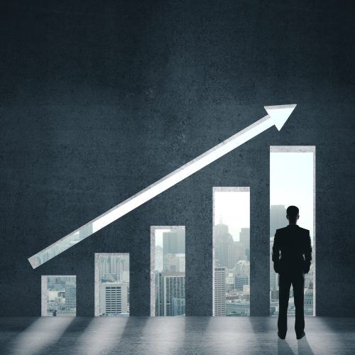 Businessman looking on stock chart on wall. Business and financial success concept